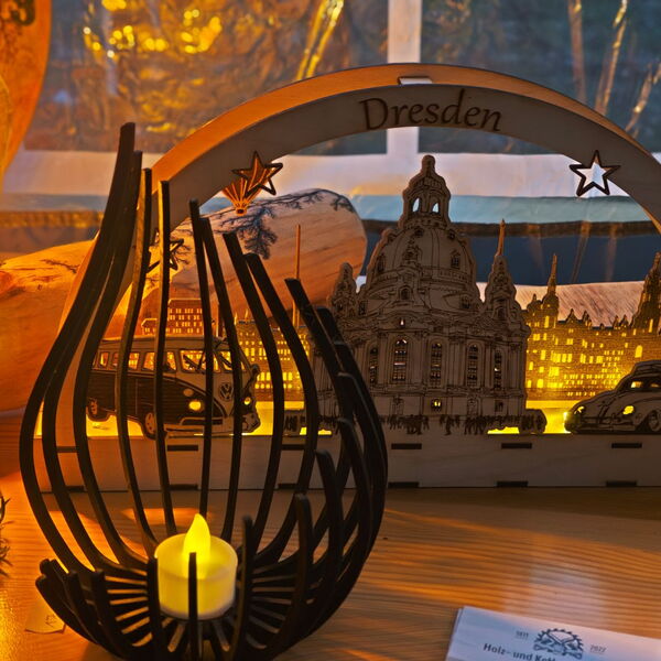 Holz-und-Kettensägekunst aus Oberwartha 2025: Schwibbogen mit Dresdner Frauenkirche in der Mitte, rechts ein alter VW Käfer, links ein VW Bulli